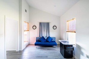 A room with a blue sofa, a pool table, and two wall decorations. - Unit A of Crystal Beach's Premier Triplex 2Bd 1Bth (Bolivar Peninsula)
