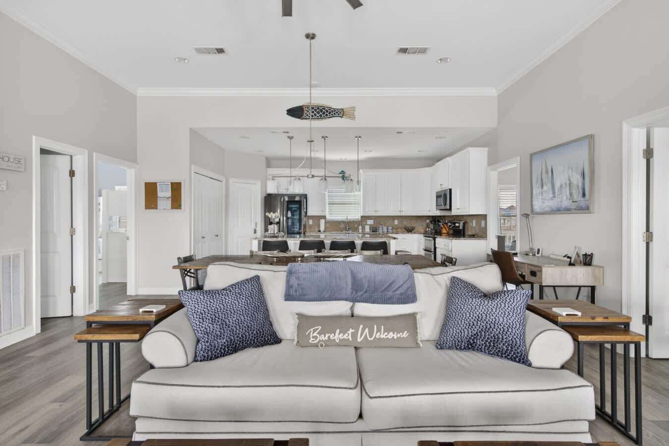 A modern living room with a sofa, coffee table, and a dining area in the background.