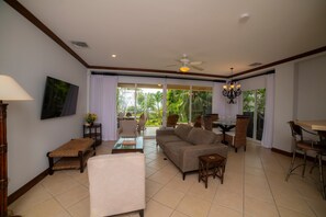 A spacious living area with a sofa, chairs, a dining table, and a ceiling fan. - Bay Residence 8C 3 bdr 2 bath (Herradura)
