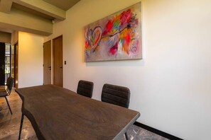 A conference room with a long table and four chairs, a colorful abstract painting on the wall, and a door in the background. - Capitalia ,Terrace, Rooftop Jacuzzi, Gym & more (Ciudad de México)