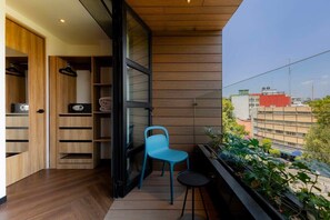 A balcony with a blue chair, a small table, and a potted plant. - Capitalia ,Terrace, Rooftop Jacuzzi, Gym & more (Ciudad de México)