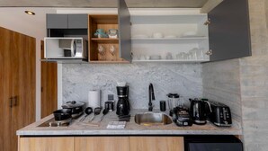 Una cucina moderna con forno a microonde integrato, macchina da caffè, tostapane e lavello.