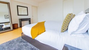 Quarto com cama, espelho, lareira e porta.