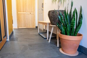 A hallway with a wooden door, a bench, and a potted plant. - Artsy Apt in Lawrenceville with deck & parking (Pittsburgh)