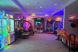 Eine Indoor-Spielehalle mit verschiedenen Spielautomaten, darunter Rennspiele und Krabschlingen.