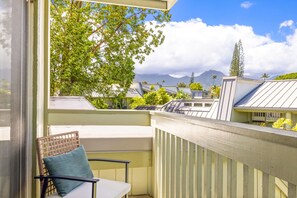Un balcone con vista su una catena montuosa, una sedia e un tavolo.