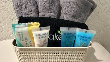 Una cesta con productos de cuidado de la piel Bergman Kelly y una toalla negra.