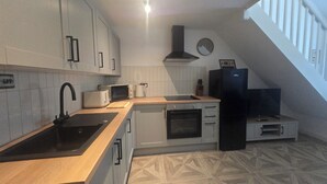 Une cuisine moderne équipée d’un évier, d’un four à micro-ondes, d’un grille-pain et d’une cuisinière.