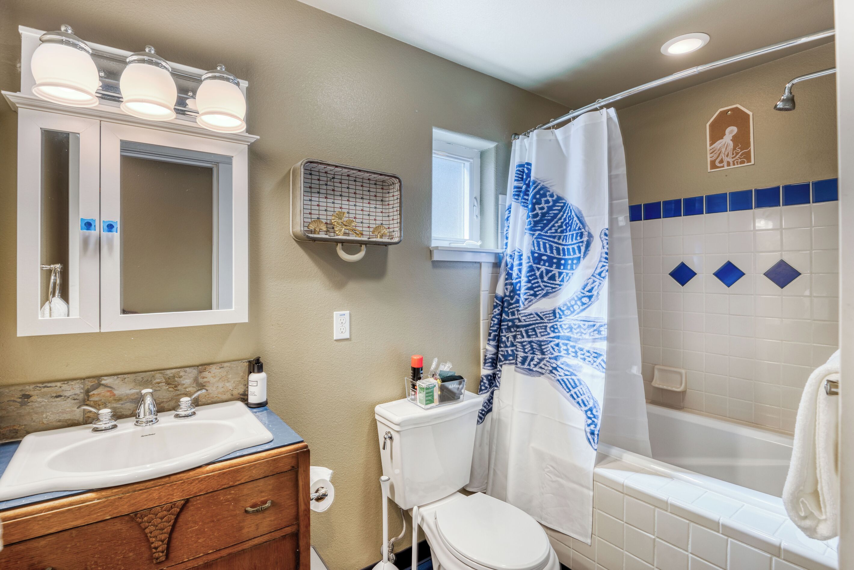 Une salle de bain équipée d’un lavabo, d’un miroir, de toilettes et d’une douche.