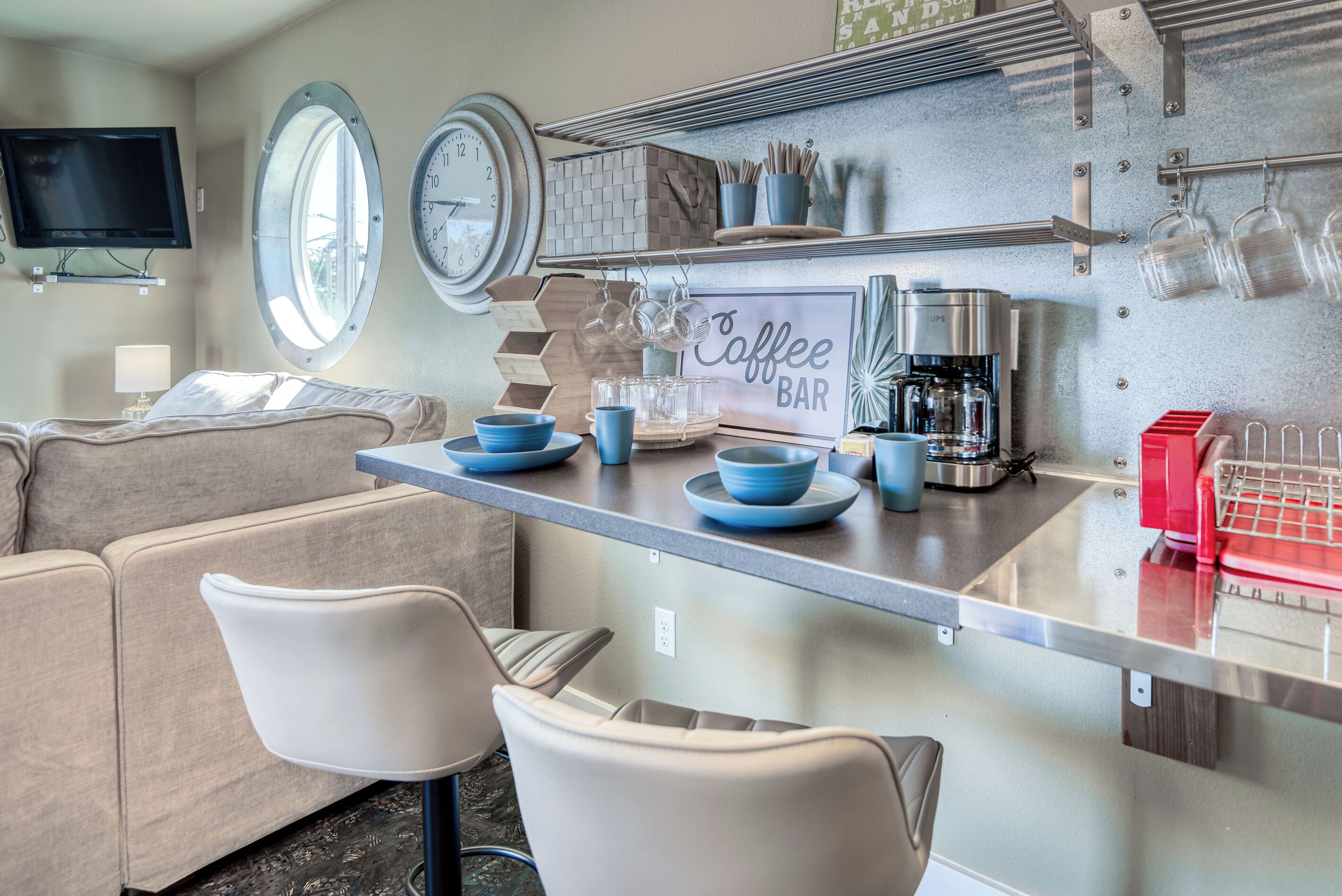 Um espaço compacto com cozinha compacta, sofá e área de bar com café.