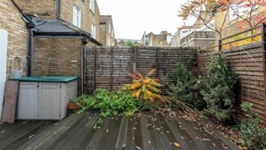 A wooden deck with a shed and a fence. - Tranquil & Family-friendly 3BD Home, Clapham! (London)