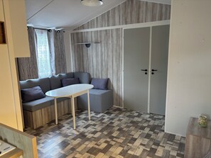 Ein stilvolles Zimmer mit grauem Sofa, einem kleinen Tisch, einem Kleiderschrank und einem gemusterten Boden.