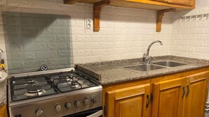 Cuina amb fornell de gas, forn i doble rentaplat.