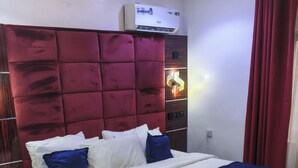 Ein Bett mit rotem Kopfteil, weißer Bettwäsche und blauen Akzenten.