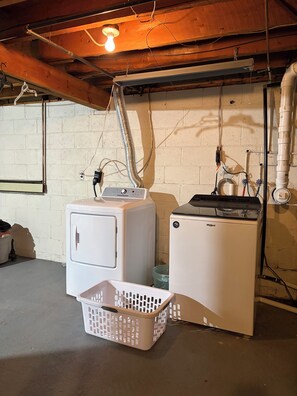 A laundry area with two white washing machines, a hanging rack, and a plastic basket. - Spacious Wisconsin Northwoods Escape -Private Fire Pit and Close Water Access (Porterfield)