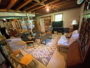 A living room with a sofa, a coffee table, a TV, and a fireplace.