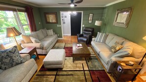 A living room with two sofas, a coffee table, a floor lamp, and a ceiling fan.