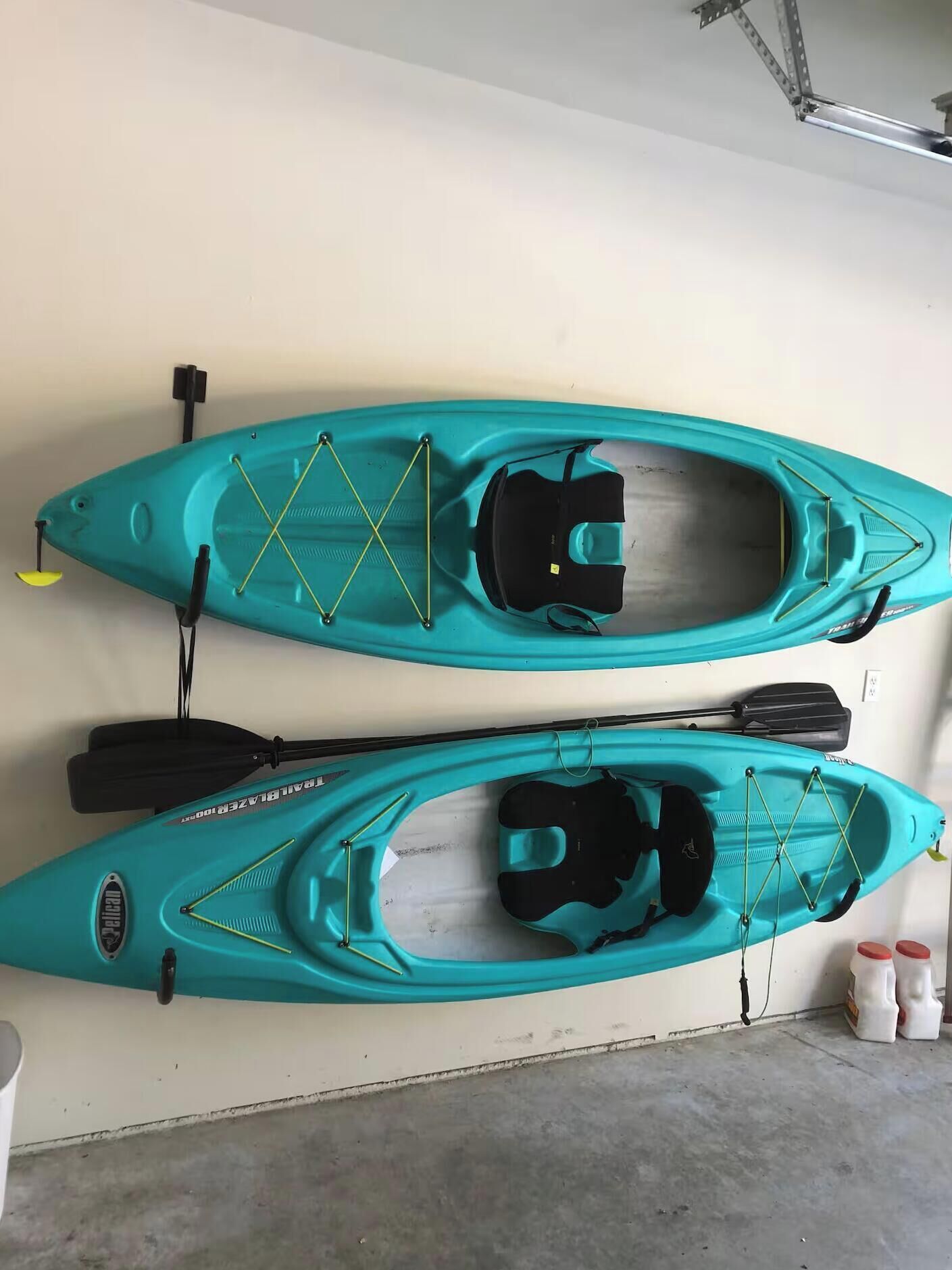 Two kayaks mounted on a wall in a garage.