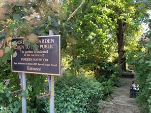 Indicador d'entrada al jardí dedicat a Doreen Haywood, amb un camí que s'endinsar al jardí.