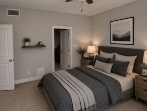 A bedroom with a bed, bedside tables, a lamp, a framed picture on the wall, and a door leading to another room. - Luxury Houston Getaway 3BR, 3.5BA, Sleeps 8, Near Downtown (Houston)