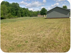 A grassy field with a building and trees in the background. - Quaint 1-Bedroom House in Charming Sumter (Sumter)