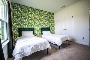 A bedroom with two beds, a green headboard, and a white door. - Spacious Gulf Breeze Retreat: Near Pensacola & Navarre Beaches & Dining (Gulf Breeze)