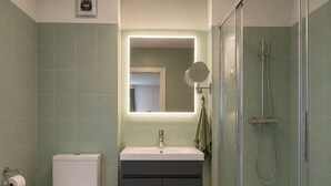 A modern bathroom with a toilet, sink, and shower. - Pension Ursula (Pfaffstätten)