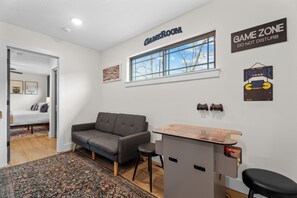 Ein Zimmer mit grauem Sofa, einer kleinen Bar und einem Fenster mit Aussicht.