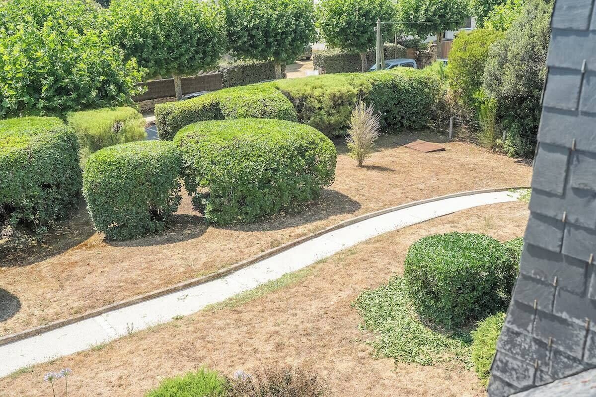 A landscaped garden with neatly trimmed hedges and a curved pathway.