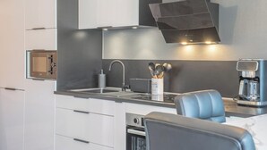 Una cocina moderna con horno integrado, cafetera y pileta.
