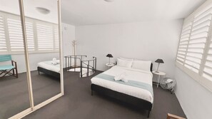 A hotel room with two beds, a chair, a small table, and a mirror. - EST11 - Balmoral Breeze | Leafy 2-Bed Duplex Garden Apartment Near the Beach (Mosman)