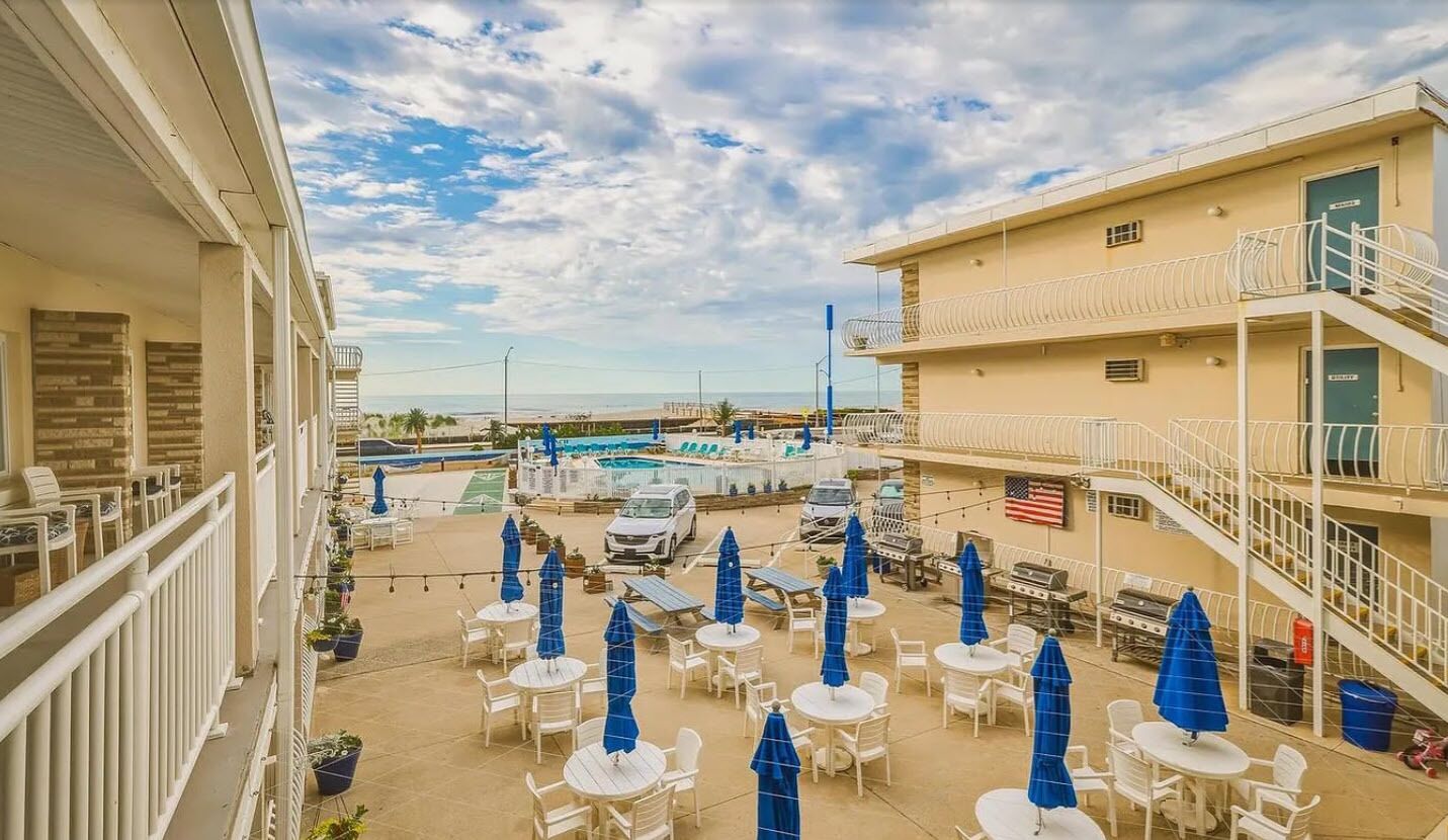 Ein Hotel mit Außenbereich, einem Pool und Blick auf den Strand.