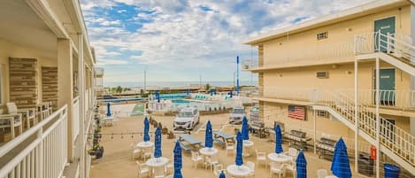 Un hotel con terraza, piscina y vistas a la playa.