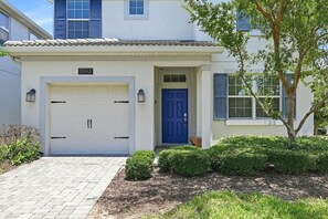 A house with a number 1593, a blue door, and a garage. - Renovated 5BR Pool Home · Game Room · 15 Min to Disney · Sleeps 10 (Four Corners)