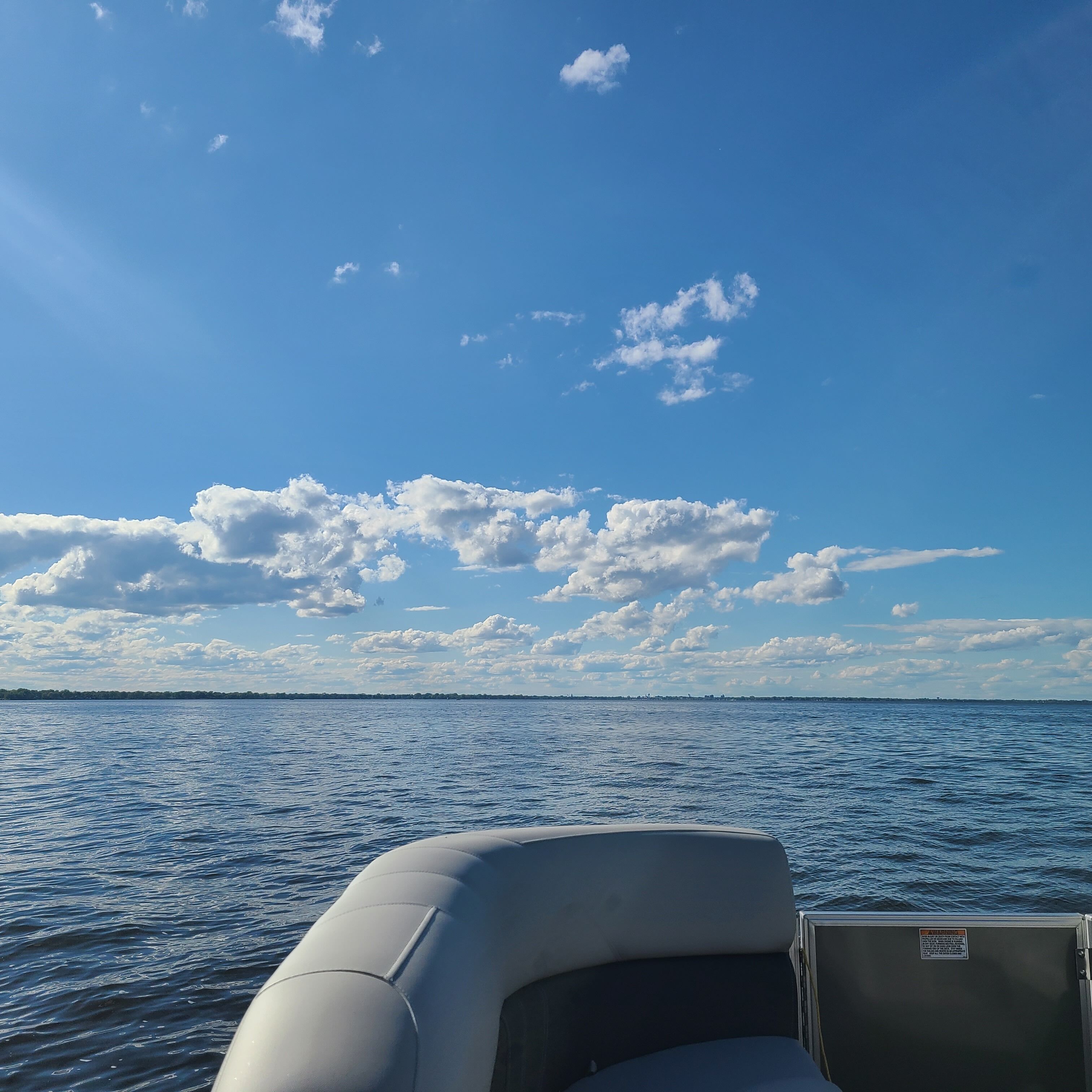Um barco com vista para a água e o céu.