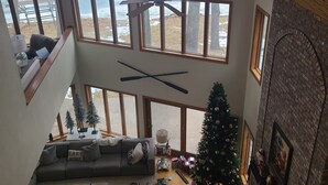 A multi-level living space with a loft area, a Christmas tree, and a fireplace. - Lakeside Retreat 4+ bedrooms 7 beds 2.5 baths (Oshkosh)