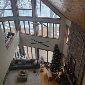 A multi-level living space with a loft area, a Christmas tree, and a fireplace. - Lakeside Retreat 4+ bedrooms 7 beds 2.5 baths (Oshkosh)