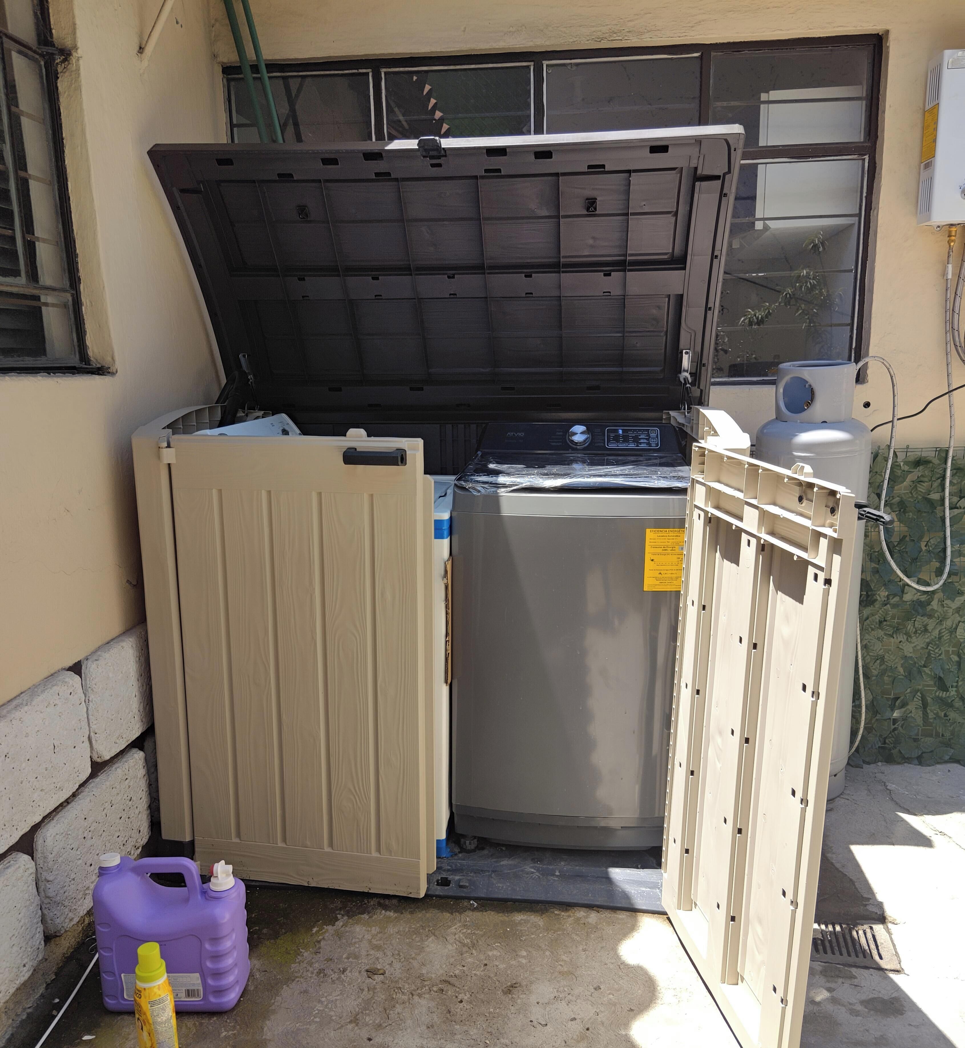Un garage con una porta dell'auto chiusa, una lavatrice e uno scaldabagno.