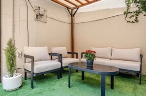 A patio area with a sofa, two chairs, a small round table, and a potted plant. - Spacious Single-Story Family Home with Garden and Parking (Near AICM and the Basilica) (Ciudad de México)