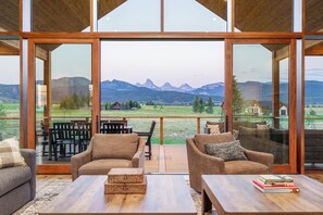 A spacious balcony with a view of mountains, furnished with two sofas and a coffee table. - Luxury Retreat, Teton Views, Sleeps 16+, Hot Tub, Fire Pit (Tetonia)