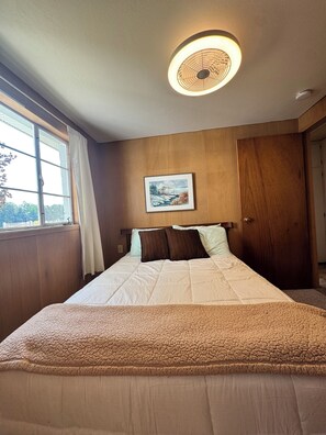 A bedroom with a bed, a ceiling light, a window, and a door. - Spacious 4-bedroom house on all sports 8 Pt Lake in wonderful Lake with AC (Lake)