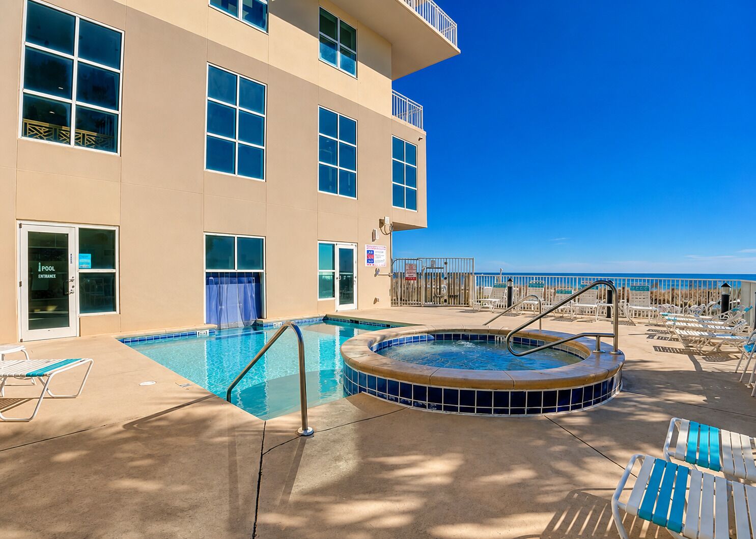 Un hotel con piscina, jacuzzi y tumbonas.