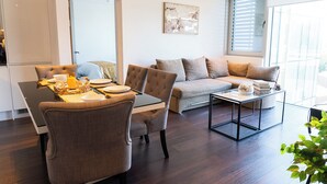 Ein modernes Wohnzimmer mit Essbereich, einer Sofagarnitur und einem Couchtisch.