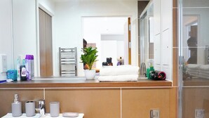 Ein modernes Badezimmer mit Waschbecken, Toilette und einem großen Spiegel.