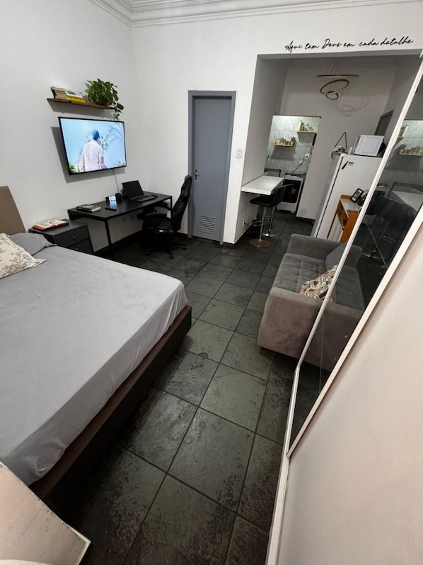 A bedroom with a bed, a desk, a chair, and a television. - Studio Copanema (Rio de Janeiro)