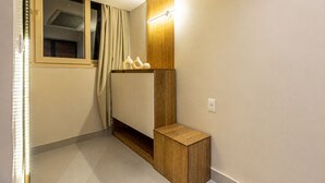 Ein modernes Badezimmer mit einem Holzlagerfeld, einem Handtuchhalter und einem Fenster mit Vorhängen.