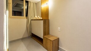 Ein modernes Badezimmer mit einem Holzlagerfeld, einem Handtuchhalter und einem Fenster mit Vorhängen.