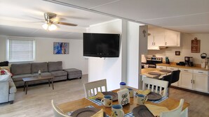 A modern living space with a dining area, kitchen, and a ceiling fan. - Near Kentucky lake Running bear cottage ! (Gilbertsville)