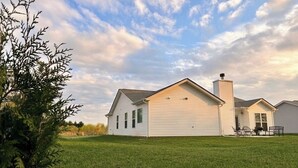 A single-story house with a sloped roof, a chimney, and a well-maintained lawn. - Brand New Home! Modern Lake Retreat: 1 Mi to Water & Boat Parking (Hartwell)