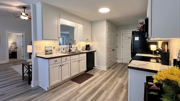 A modern kitchen with white cabinetry, a central island, and a built-in oven. - Brand New Home! Modern Lake Retreat: 1 Mi to Water & Boat Parking (Hartwell)